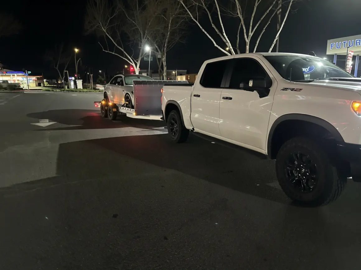 Pickup truck towing the Club Sport trailer at night
